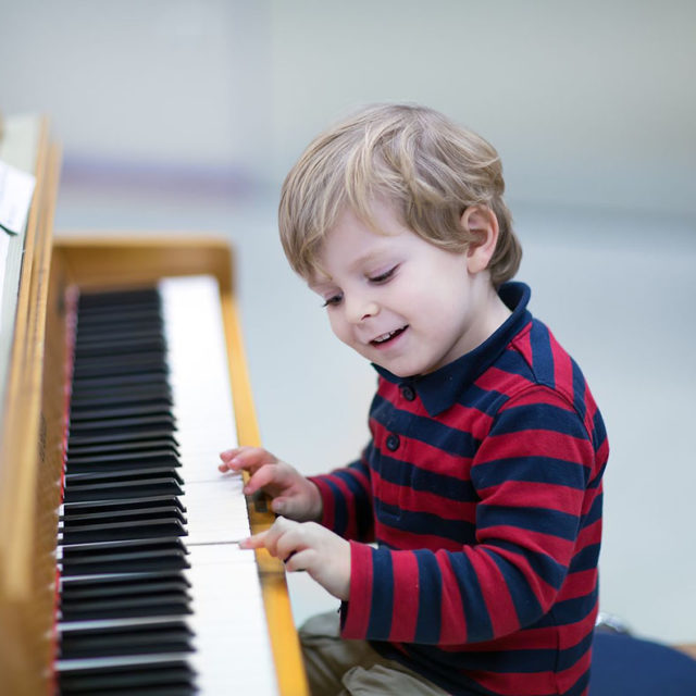 16660334 - two years old happy toddler boy playing piano